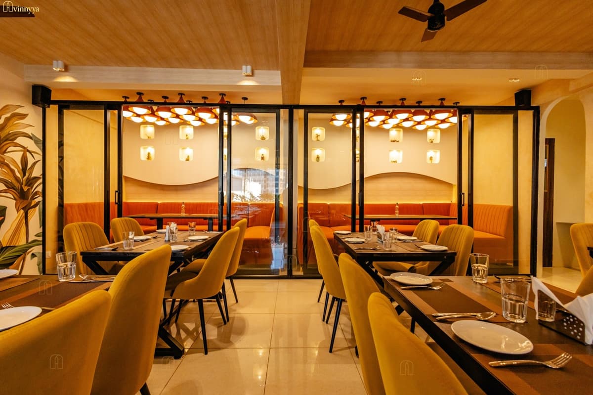 Restaurant interior with mustard seating and a glass partition — Tastique, Bangalore