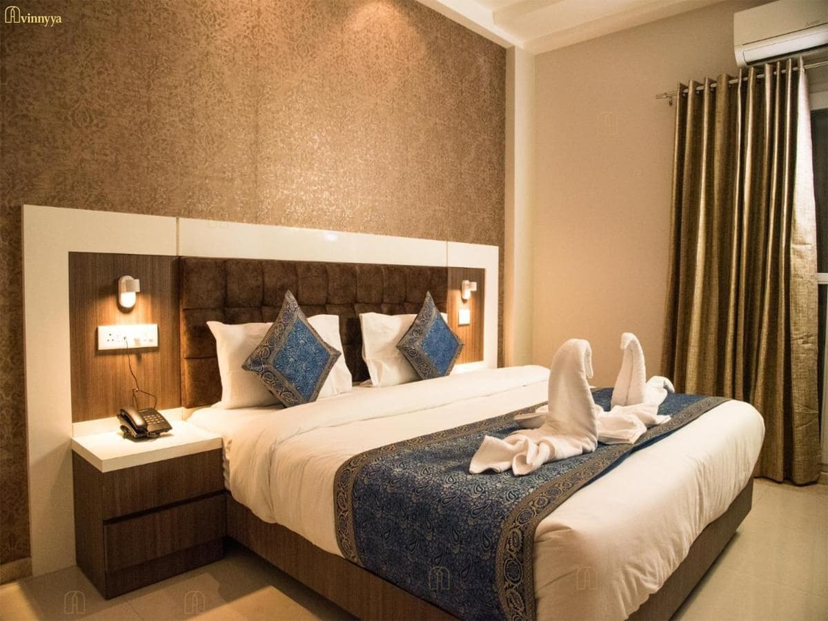 Hotel room with a padded headboard and bedside lamps — 36 Avenue, Varanasi